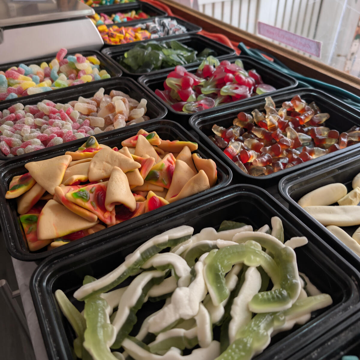 A selection of pick and mix sweets in black tubs.